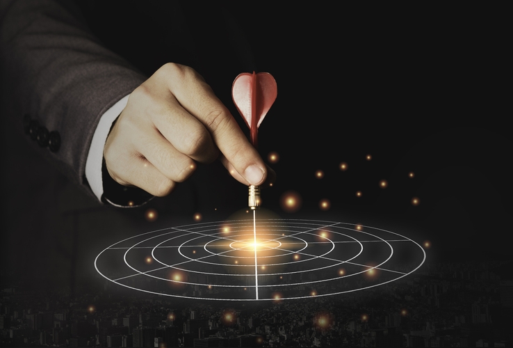 Executive marketing hand holding red dart put to centre of targe