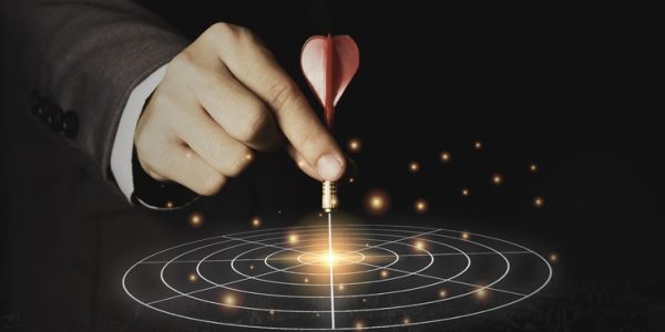 Executive marketing hand holding red dart put to centre of targe